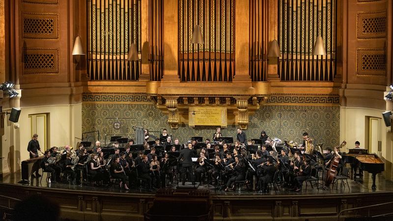 Stage wide angle of concert band with organ pipes in the background