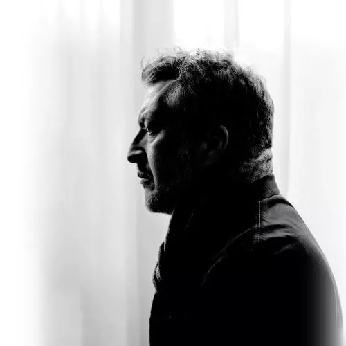 Man in coat staring off to left hand side in black and white