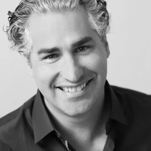 man smiling at the camera in black shirt in black and white